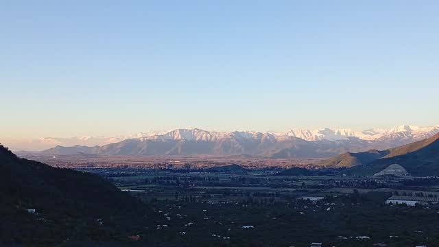 Panorámica del valle al atardecer con la cordillera nevada de fondo