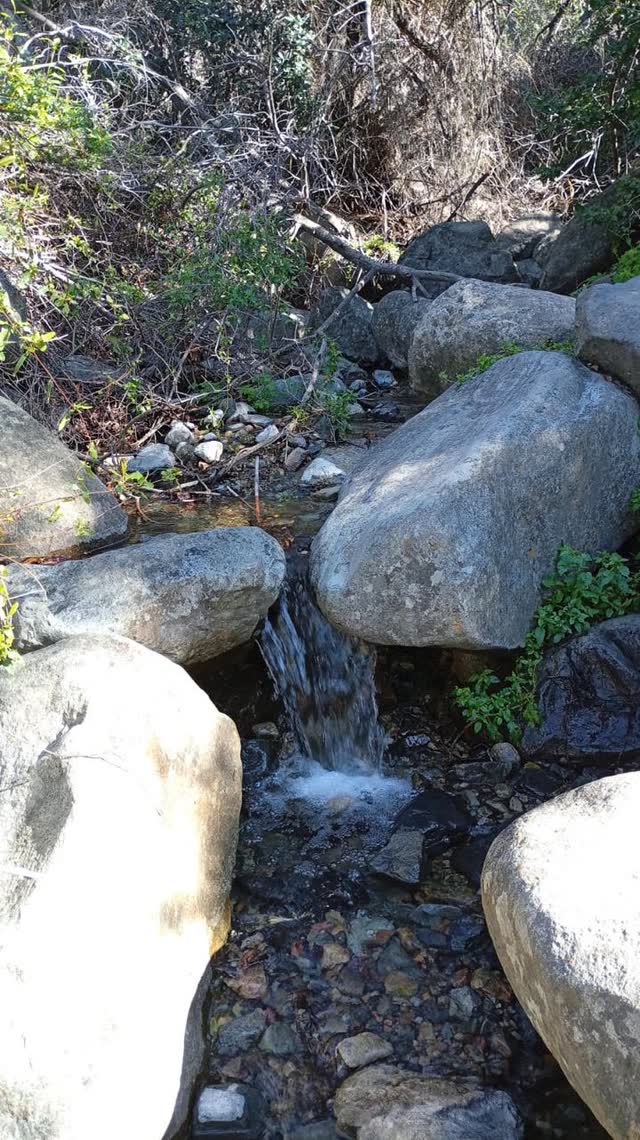 Pequeño salto de agua cayendo entre grandes rocas
